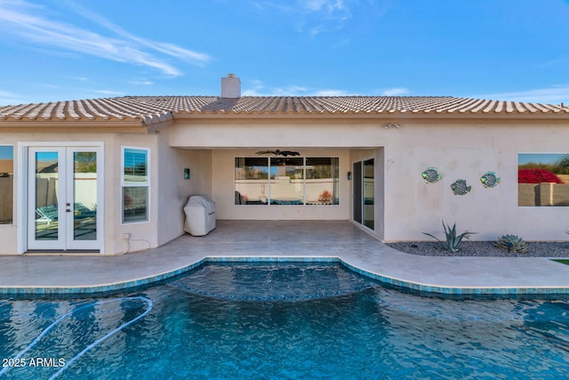 view of pool with french doors, a patio area, and ceiling fan