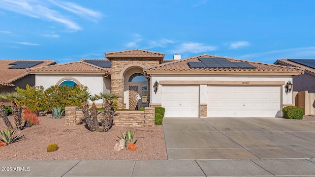 view of front facade featuring solar panels and a garage