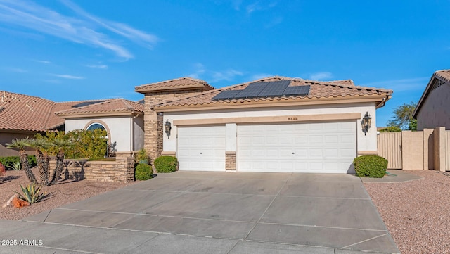 mediterranean / spanish-style house featuring solar panels and a garage