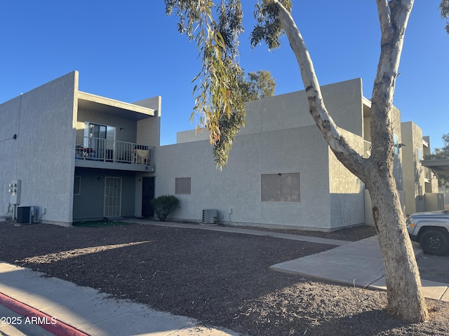 view of side of home featuring a balcony and cooling unit