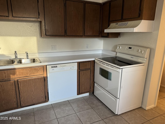 kitchen featuring custom exhaust hood, light tile patterned floors, sink, and white appliances