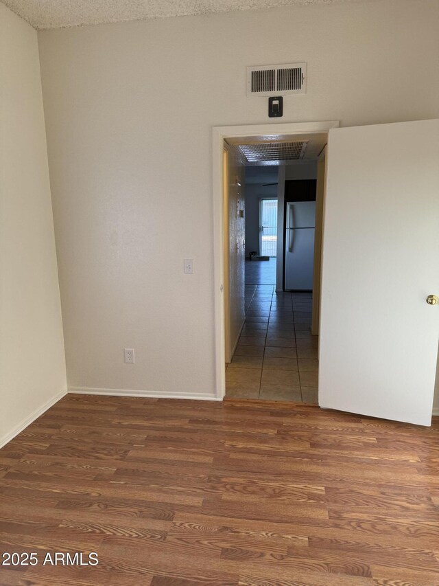 spare room featuring a textured ceiling and hardwood / wood-style floors