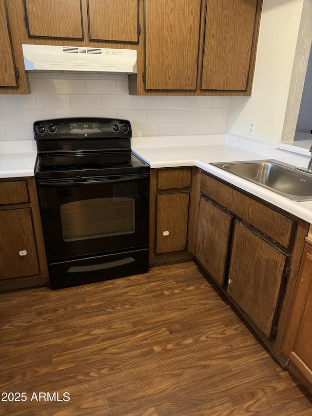 kitchen with decorative backsplash, electric range, sink, and dark hardwood / wood-style flooring