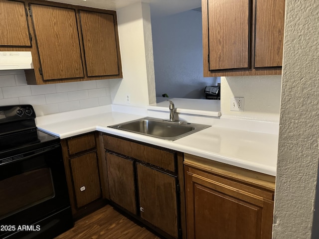 kitchen featuring dark wood-type flooring, black electric range, backsplash, and sink