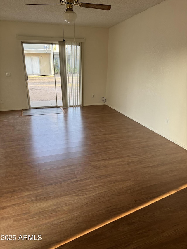 spare room with a textured ceiling, ceiling fan, and hardwood / wood-style floors