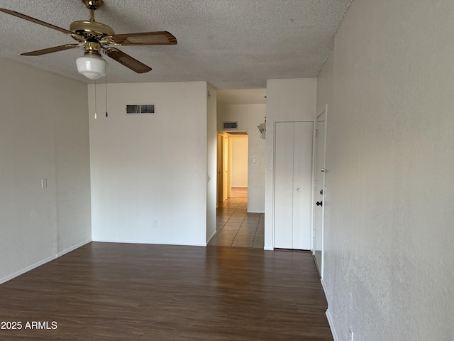 unfurnished room featuring ceiling fan, a textured ceiling, and dark hardwood / wood-style floors