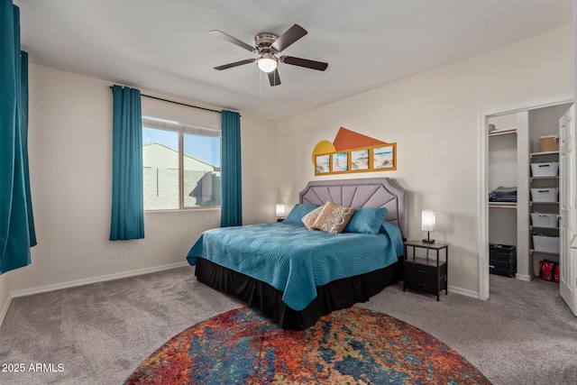 carpeted bedroom with ceiling fan, a spacious closet, and a closet