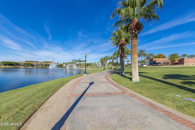 view of home's community with a water view and a lawn