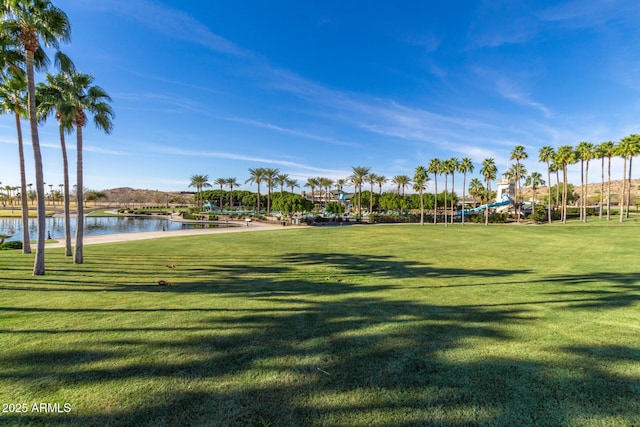 view of home's community with a lawn and a water view