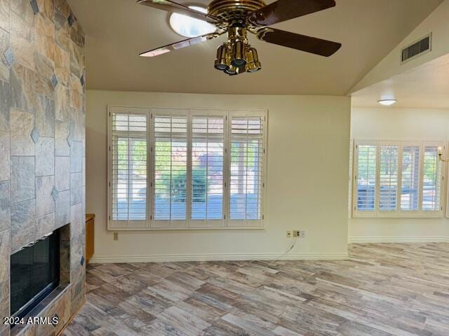 unfurnished living room with a tile fireplace, hardwood / wood-style floors, ceiling fan, and lofted ceiling