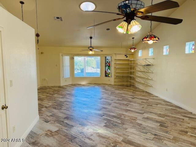 unfurnished living room with ceiling fan, hardwood / wood-style floors, and high vaulted ceiling