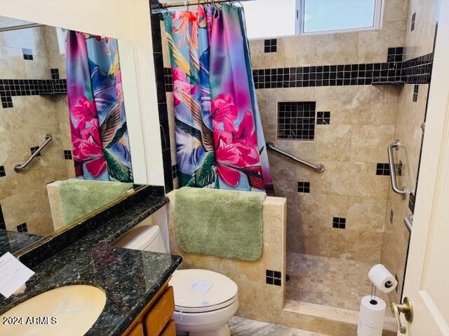 bathroom featuring curtained shower, vanity, and toilet