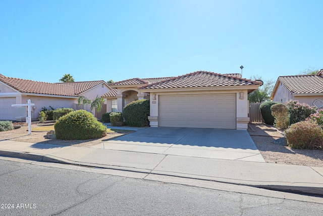 7275 W Tina Ln, Glendale, AZ 85310 - mediterranean / spanish home with stucco siding, concrete driveway, an attached garage, and a tiled roof