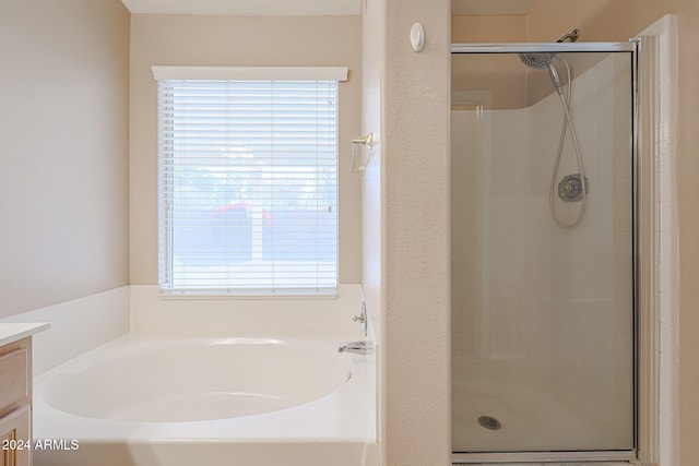 bathroom with vanity and shower with separate bathtub