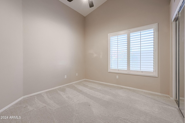 carpeted empty room with vaulted ceiling and ceiling fan