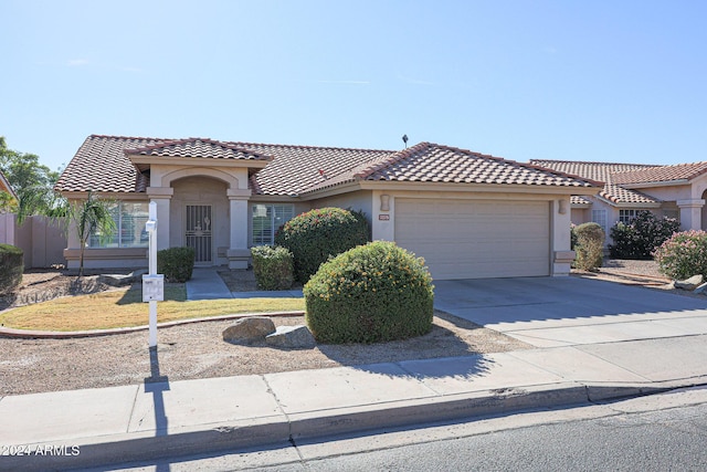 7275 W Tina Ln, Glendale, AZ 85310 - mediterranean / spanish-style house with an attached garage, stucco siding, a tile roof, and driveway