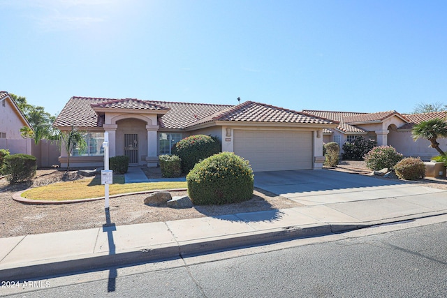 7275 W Tina Ln, Glendale, AZ 85310 - mediterranean / spanish-style house with an attached garage, stucco siding, driveway, and a tile roof