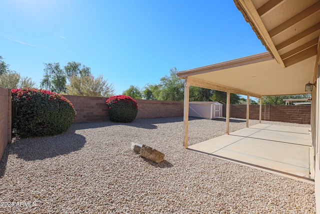 view of yard featuring a shed and a patio