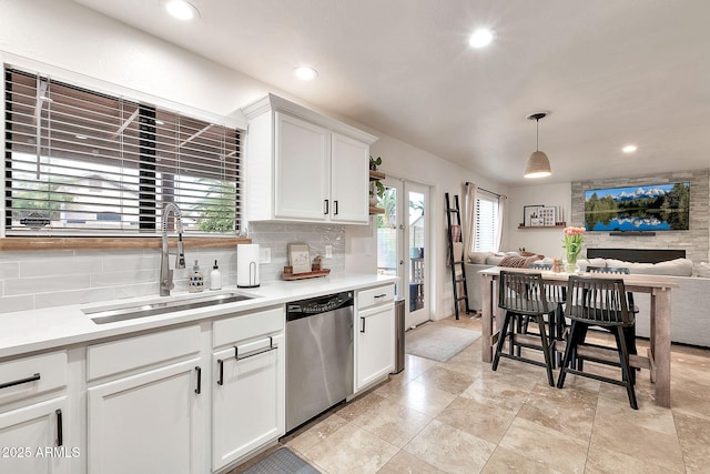 kitchen with pendant lighting, sink, stainless steel dishwasher, and white cabinets