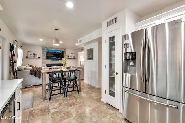 kitchen with white cabinetry, pendant lighting, and stainless steel fridge with ice dispenser