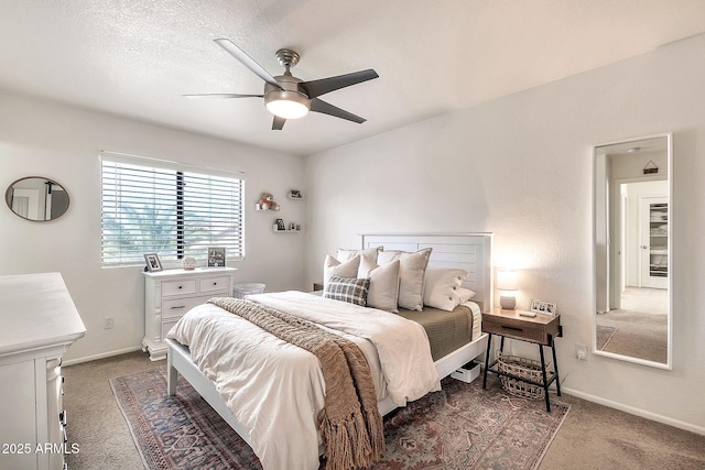 bedroom featuring ceiling fan, a textured ceiling, and dark colored carpet