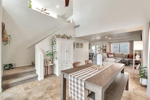 dining space with ceiling fan and a towering ceiling