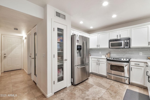 kitchen featuring white cabinetry, stainless steel appliances, and tasteful backsplash