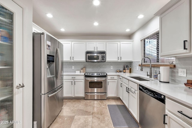 kitchen featuring white cabinetry, sink, tasteful backsplash, and appliances with stainless steel finishes