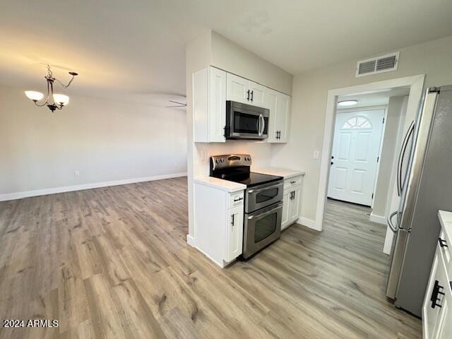 kitchen with white cabinets, a notable chandelier, light hardwood / wood-style floors, and appliances with stainless steel finishes