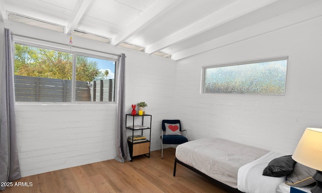 5809 N 10th Pl, Phoenix, AZ 85014 - bedroom featuring brick wall, multiple windows, beam ceiling, and wood finished floors