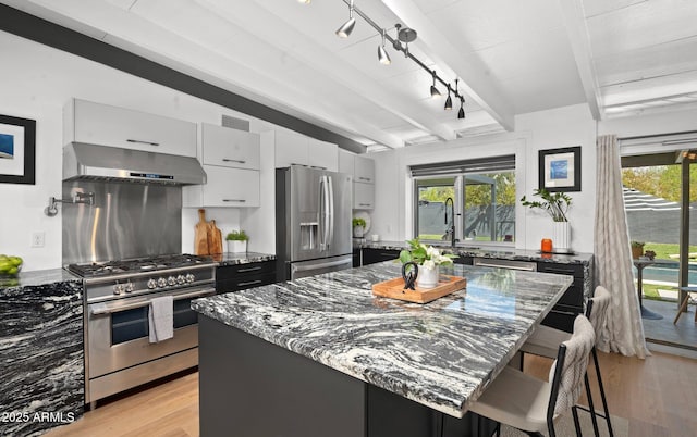 5809 N 10th Pl, Phoenix, AZ 85014 - kitchen featuring wall chimney range hood, white cabinets, visible vents, beam ceiling, and appliances with stainless steel finishes
