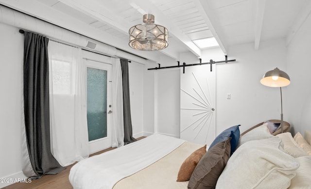 5809 N 10th Pl, Phoenix, AZ 85014 - bedroom featuring beamed ceiling, a barn door, a notable chandelier, and wood finished floors