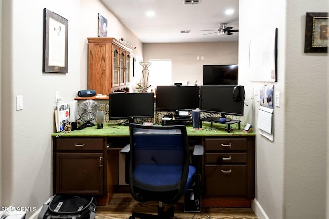 office with built in desk and ceiling fan