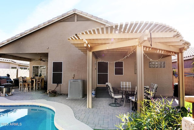 back of property featuring a pergola, an outdoor bar, ceiling fan, a fenced in pool, and a patio