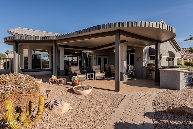 back of property with a patio area and exterior kitchen