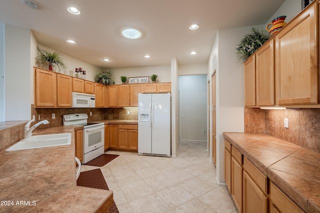 kitchen with tasteful backsplash, sink, light tile patterned floors, and white appliances