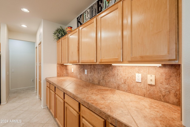 kitchen featuring decorative backsplash, light tile patterned floors, and light brown cabinetry