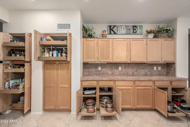 kitchen featuring tasteful backsplash, light brown cabinetry, and light tile patterned floors