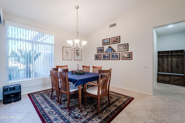 dining area with light tile patterned flooring, vaulted ceiling, and a notable chandelier