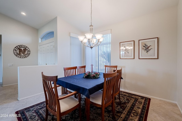 dining area with vaulted ceiling, an inviting chandelier, and light tile patterned flooring