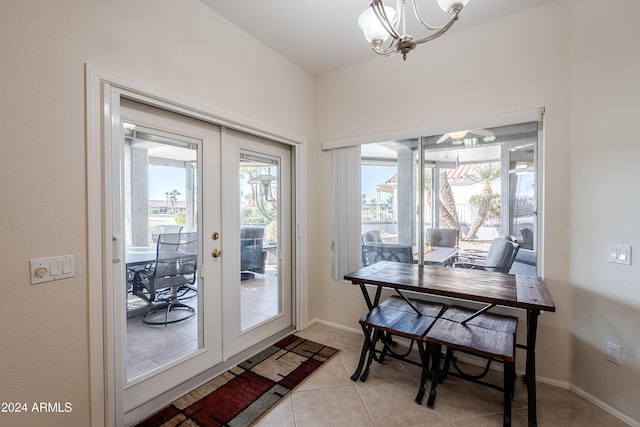 doorway with french doors, light tile patterned flooring, and an inviting chandelier