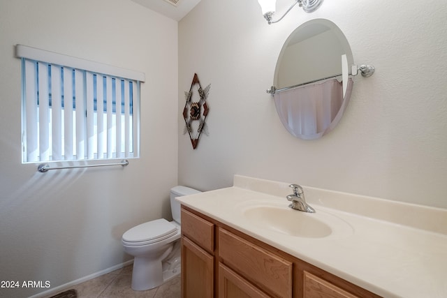 bathroom featuring tile patterned flooring, vanity, and toilet