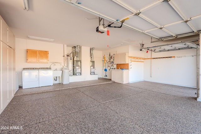 garage featuring washing machine and dryer, water heater, sink, and a garage door opener