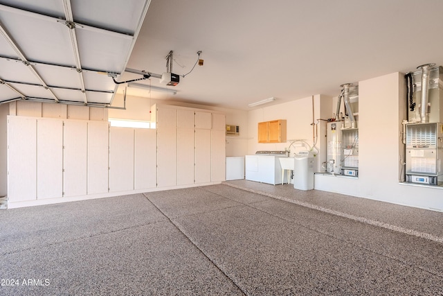 garage with washing machine and dryer, water heater, and a garage door opener