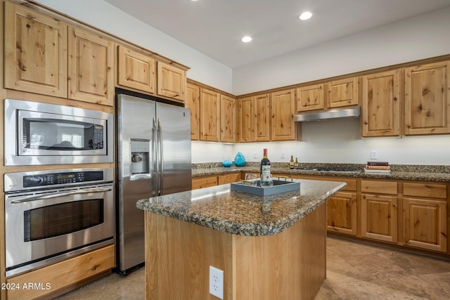 kitchen with dark stone countertops, a center island, and appliances with stainless steel finishes