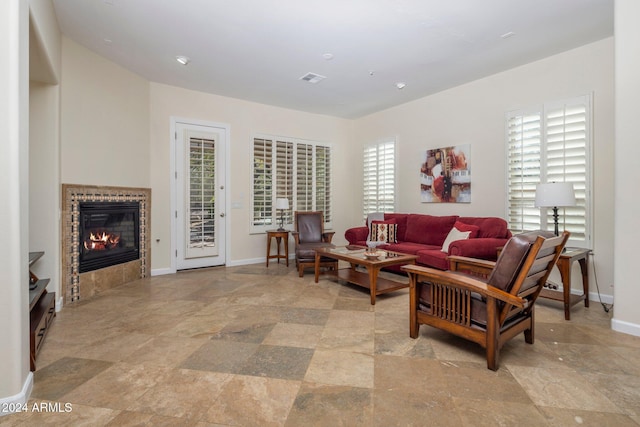 living room with a tile fireplace and a wealth of natural light