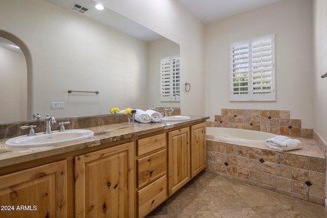 bathroom with vanity and a relaxing tiled tub