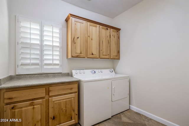 laundry room with washing machine and clothes dryer and cabinets