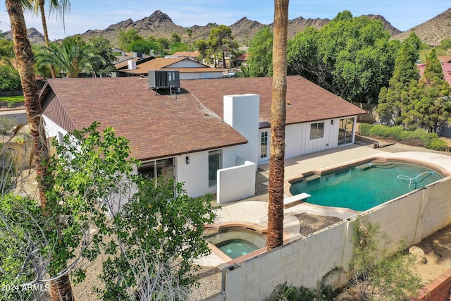 view of pool featuring a diving board, an in ground hot tub, a mountain view, central AC, and a patio area