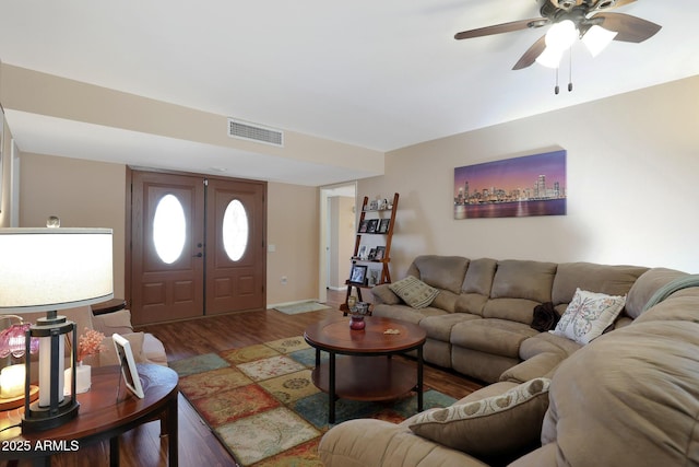 living area featuring a ceiling fan, visible vents, and wood finished floors